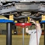 Motor Hills | Why You Need To Change Your Transmission Fluid Mechanic draing the transmission fluid from a pickup truck