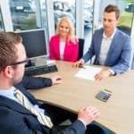 Motor Hills | Car Buying Guide: How to Negotiate a Used Car Price (The Ultimate Guide) Couple negotiating sale contact for car
