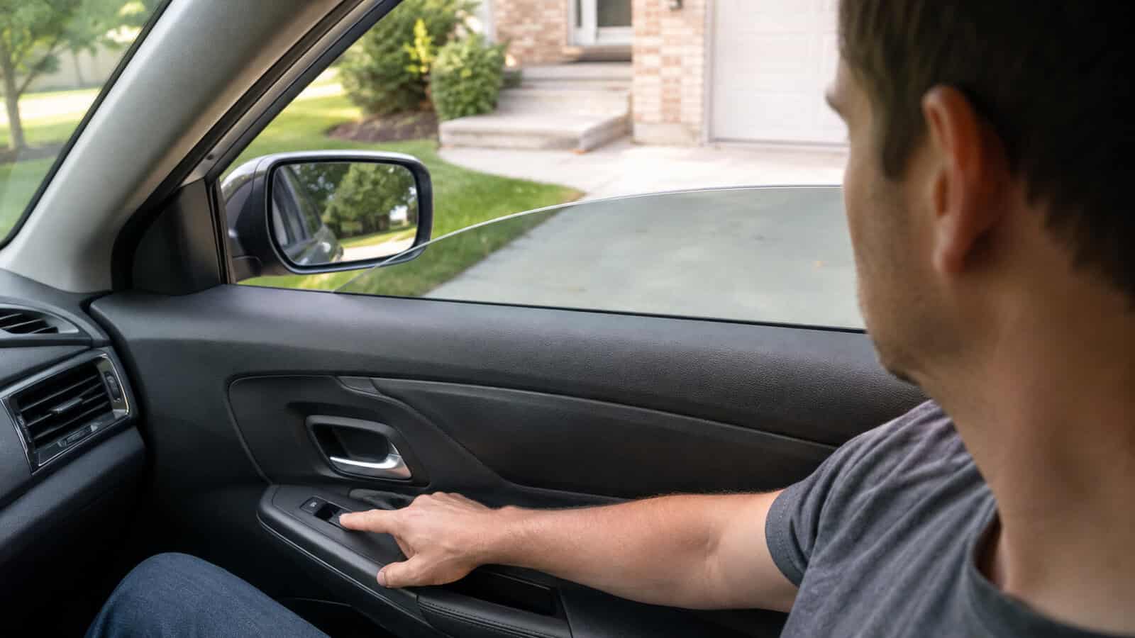 Driver using a power-window switch with the side window halfway open