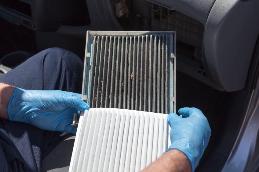 Motor Hills | How to Empty a Car AC System (DIY Guide) Comparing a dirty and brand new cabin air filter with the glove compartment storage open
