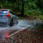 Volvo SUV traveling on a flooded road approaching a corner