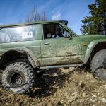Motor Hills | Why Are Beadlocks Street Illegal? Off-road Penrite H6 4x4 competition green Jeep with beadlock wheels on driving in the dirt mud