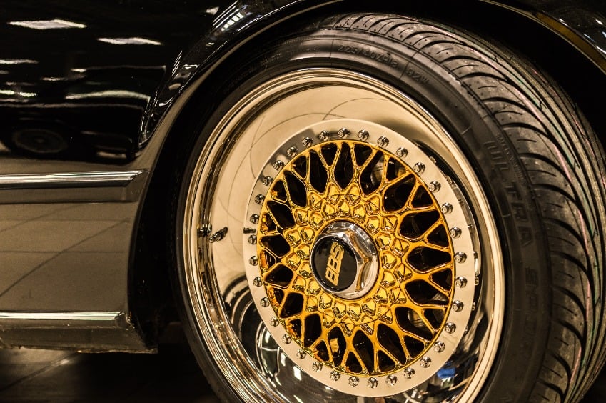 Close up of a BBS gold chrome steel wheel on a black vehicle