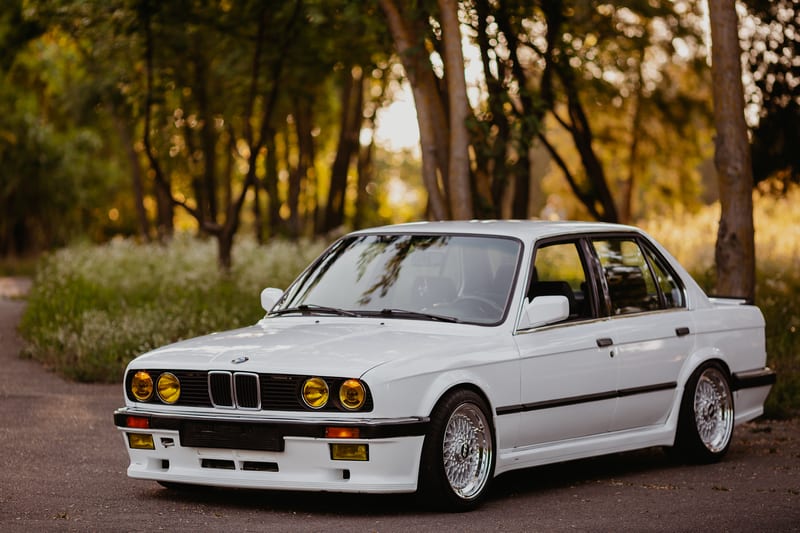 Front side shot of a white BMW E30 M3 with BBS wheels at sunset