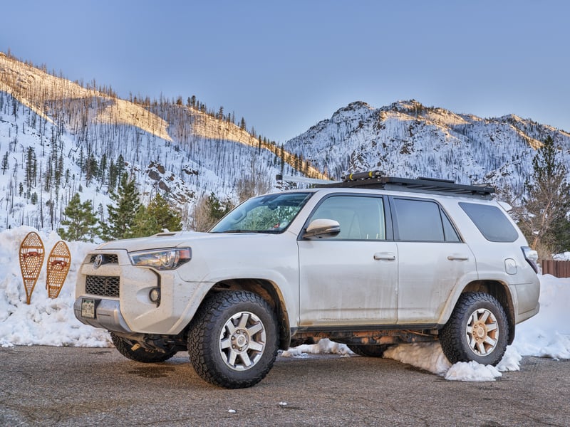 Motor Hills | 4Runner Vs Highlander Off Road: Which Is Better? Toyota 4Runner 2016 SUV in the winter with snow, mountains, and snowshoes in the background
