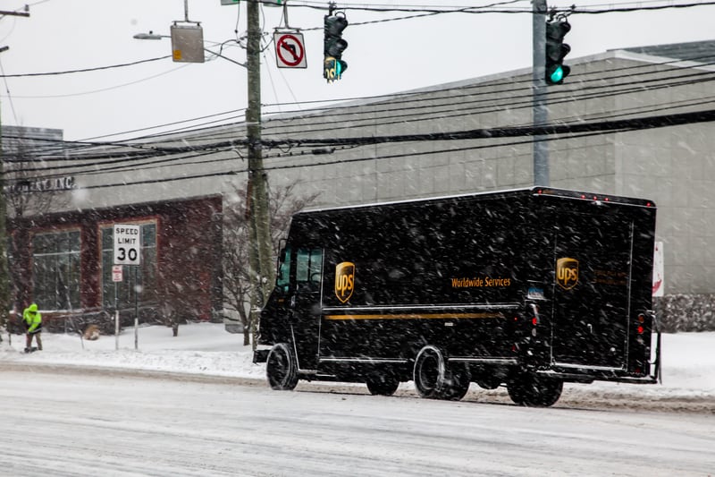 UPS truck making deliveries in rough snowy weather in the winter season in Norwalk, Connecticut, USA