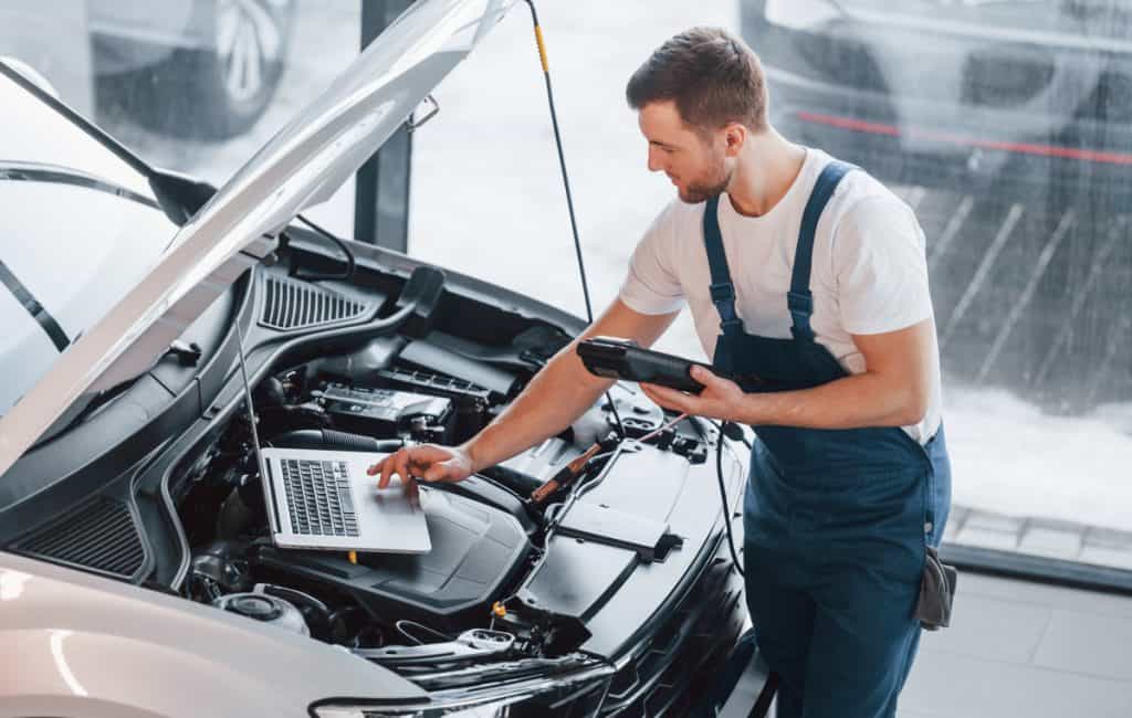 Motor Hills | Mechanics Then vs. Now: The Impact of Technology Modern Mechanics that Utilizes Laptop and scanner