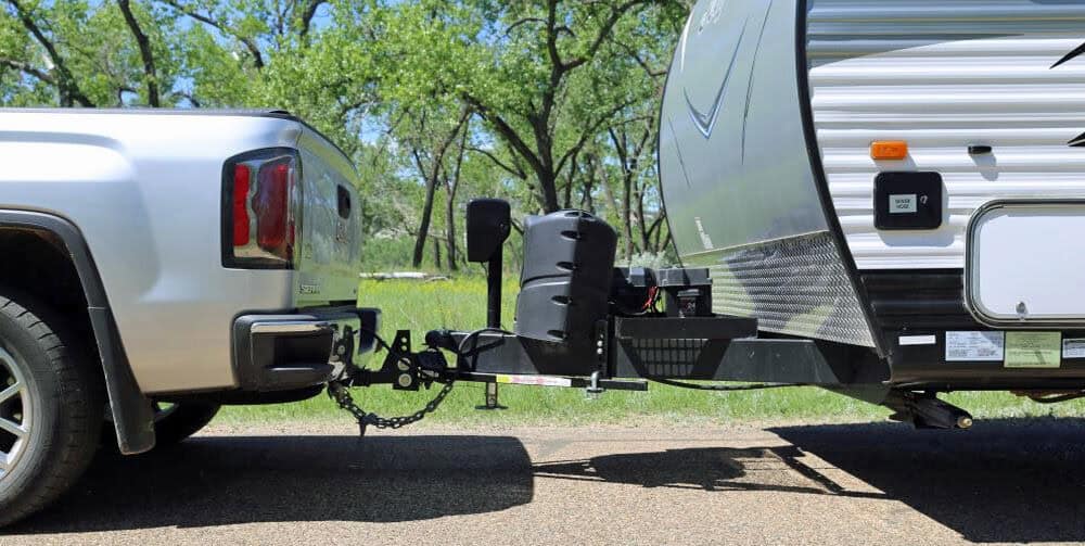 Motor Hills | Tongue Weight Explained: What It Is, Why It Matters, and How to Get It Right Modern travel trailer coupler connected to a pickup hitch, showing where tongue weight transfers to the tow vehicle