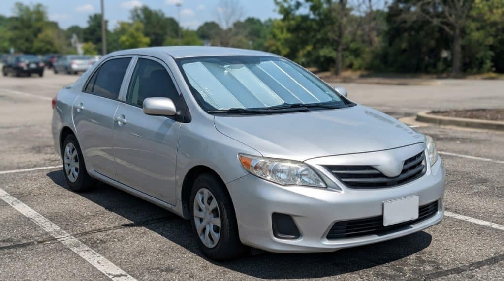 Motor Hills | Windshield Sunshade vs. Window Tint: Which Keeps Your Car Cooler? Properly fitted reflective windshield sunshade blocking sunlight from the dashboard