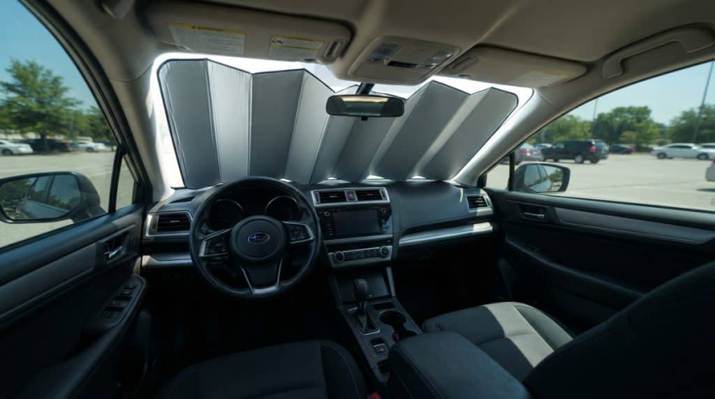Motor Hills | Windshield Sunshade vs. Window Tint: Which Keeps Your Car Cooler? Windshield sunshade keeping a car dashboard and steering wheel shaded